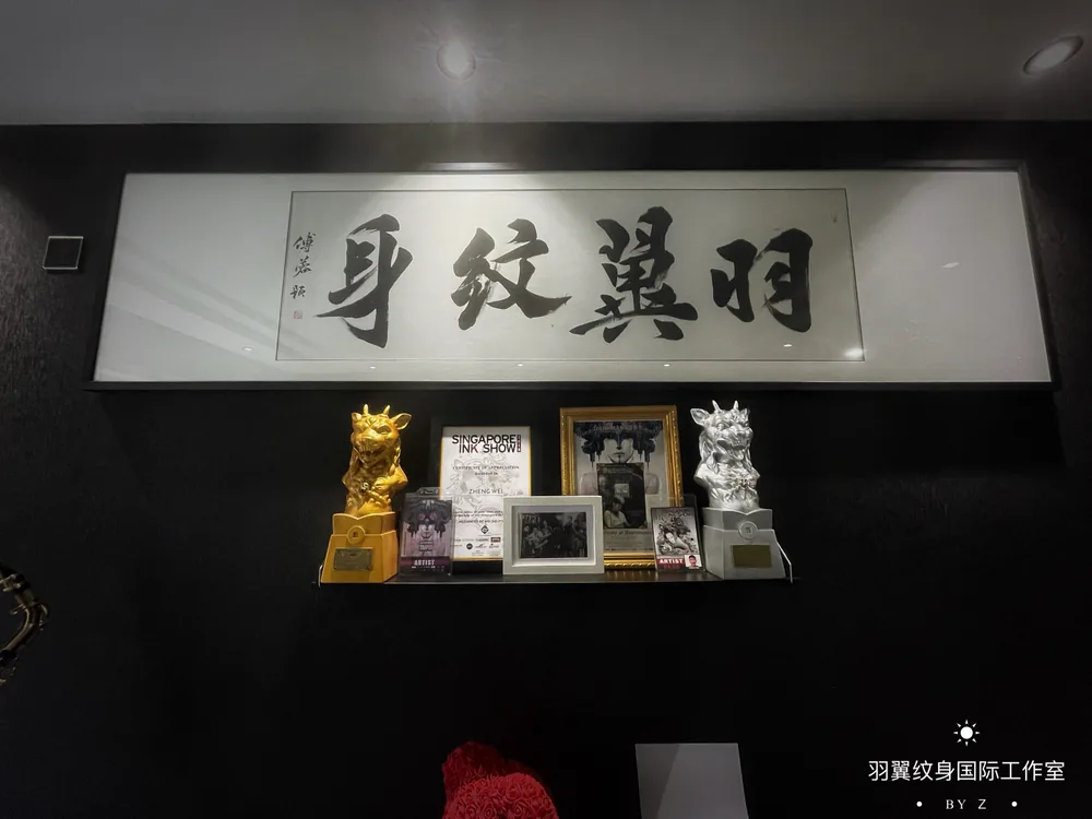 Awards shelf and Chinese calligraphy wall inside Yuyi Tattoo studio in Singapore