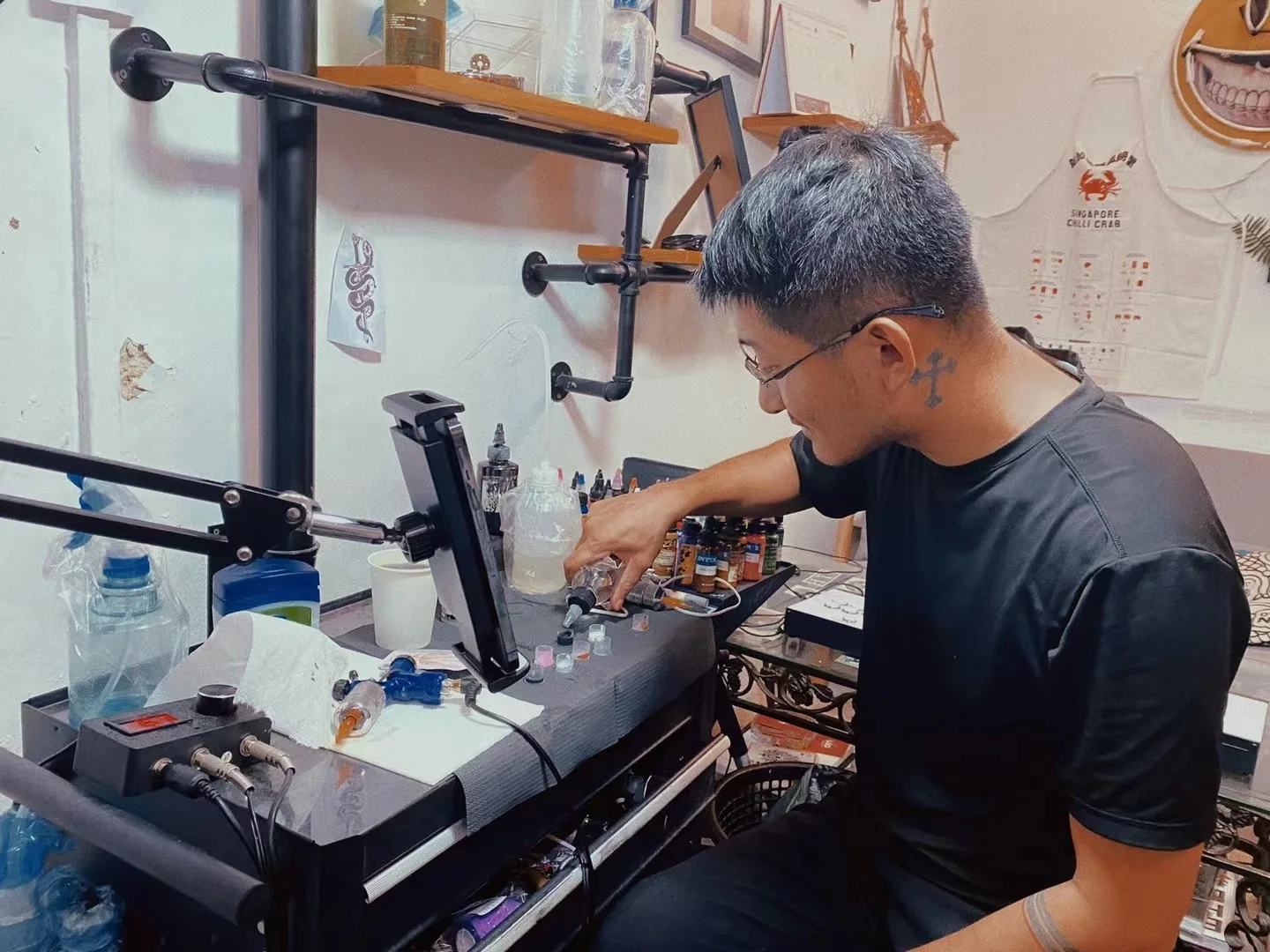 Tattoo artist preparing inks and equipment at a Yuyi Tattoo workstation in Singapore