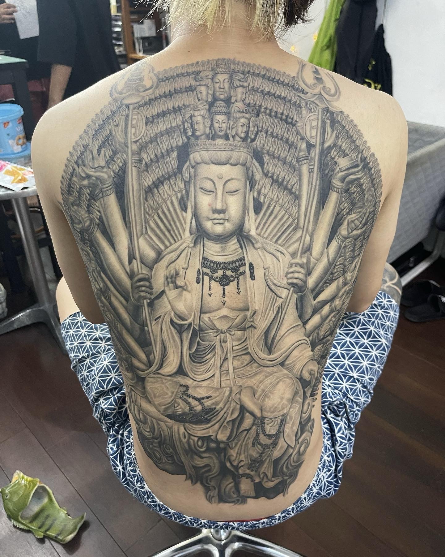 Angled view showing the Guanyin back tattoo following the shoulder and back contours