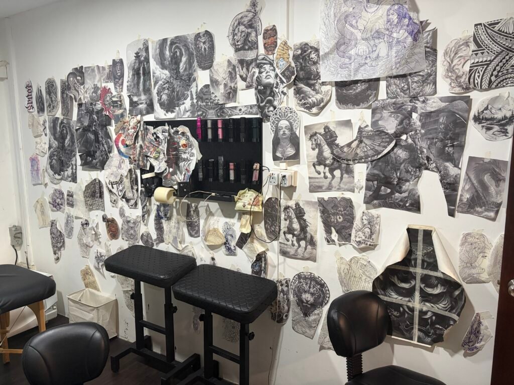 Reference studies displayed beside a tattoo workstation at Yuyi Tattoo