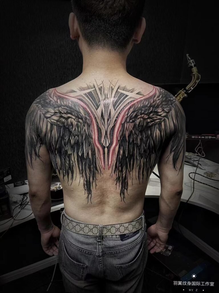 Large feathered wing tattoo spread symmetrically across the upper back